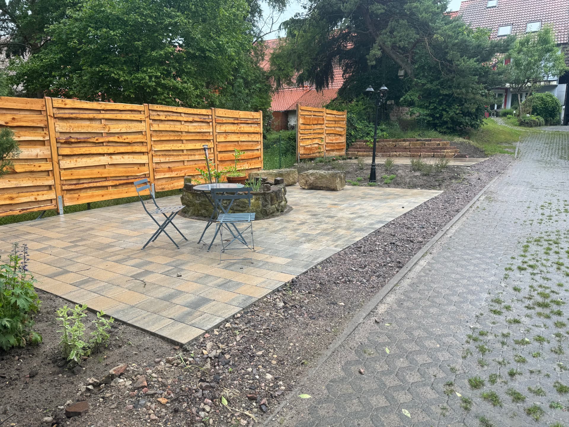 Gepflasterter Sitzplatz mit Holzzaun